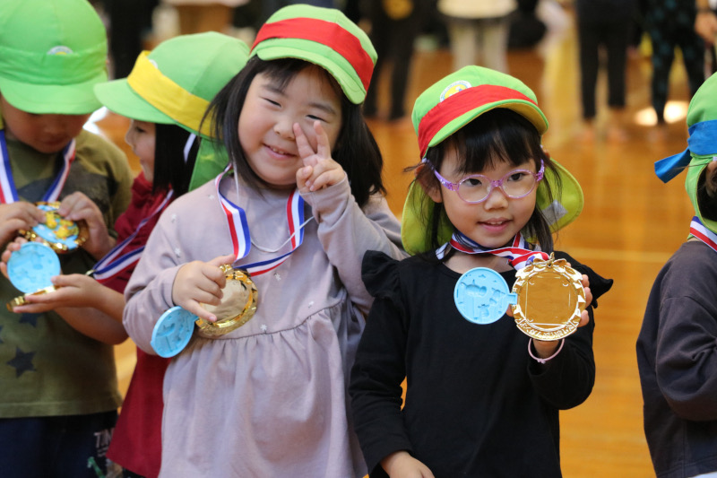 保育園の運動会。金メダルをもらってピースする園児。